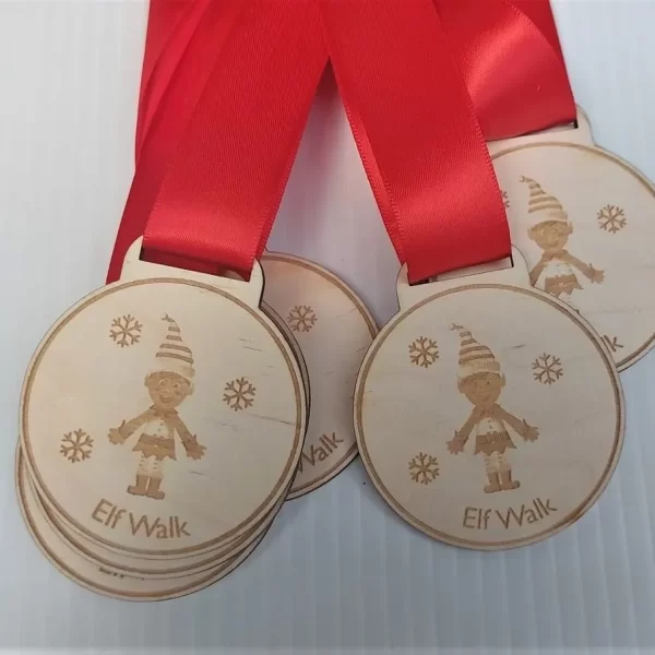 Four wooden Santa Run medals with red ribbons.