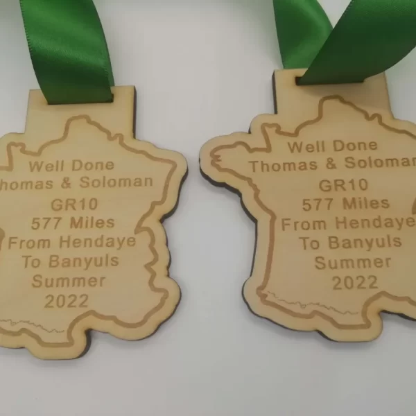 Two wooden medals with a map of france on them.