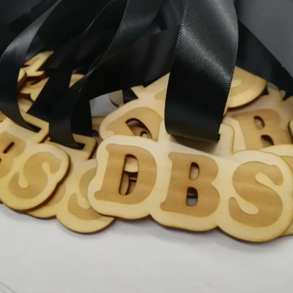 A bunch of wooden letters adorned with black ribbons, reminiscent of climbing medals.