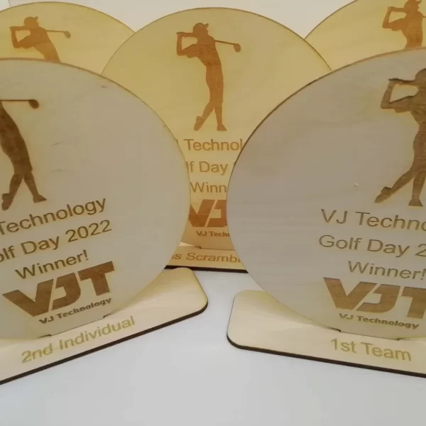 Vt technology golf day 2020 trophies featuring wooden medals.