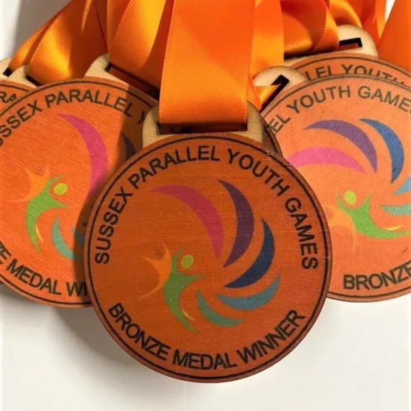 A group of Sports Day medals with orange ribbons on them.