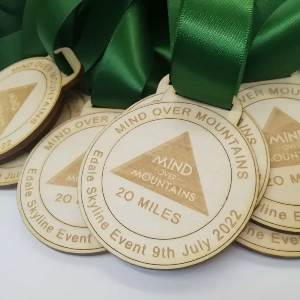 A group of wooden running medals with green ribbons.