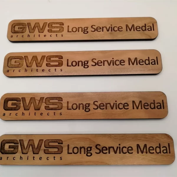 Three wooden signs with the words long service and wooden medals.