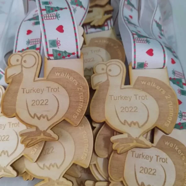 A group of wooden Santa Run medals on a table.