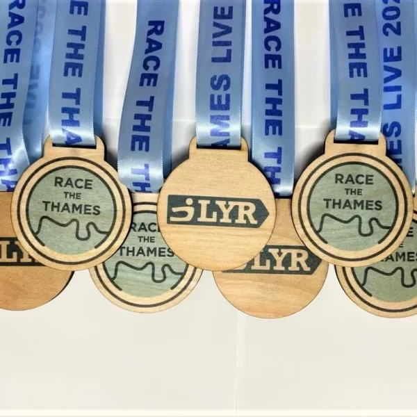 A set of wooden sailing race medals with blue ribbons.