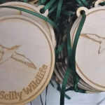 Two wooden medals with a bird on them.