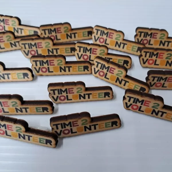 A group of wooden pins that say time 2 volunteer, resembling wooden medals.