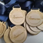 A group of wooden medals with ribbons on them.