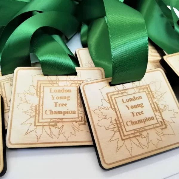 A group of green ribbons with the words 'young tree champions' on them, resembling running medals.