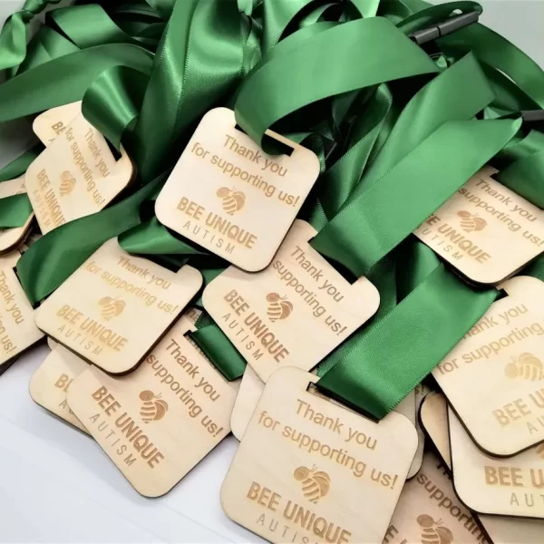A collection of wooden tags with green ribbons, ideal for use as Sports Day Medals.