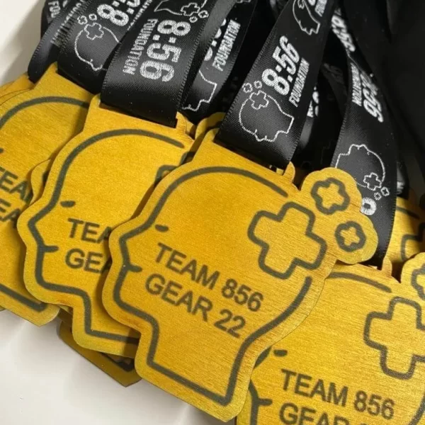 A group of running medals with the word team 886 on them.