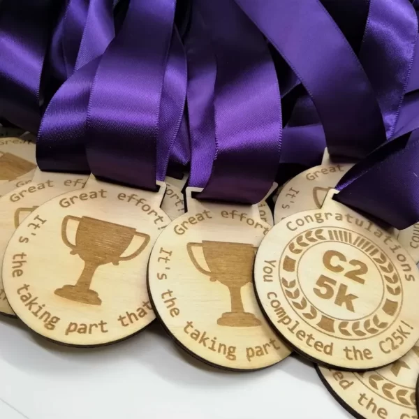 A group of wooden running medals with purple ribbons.