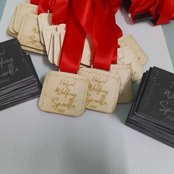 A group of wooden medals with red ribbons on them.