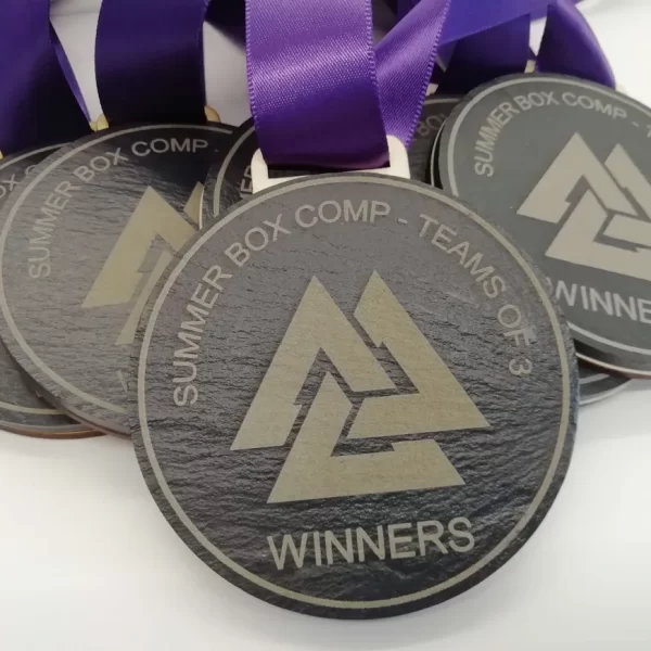 A group of climbing medals adorned with purple ribbons.