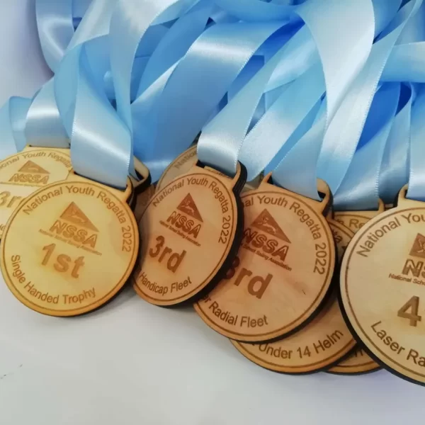 A group of sailing medals with blue ribbons.