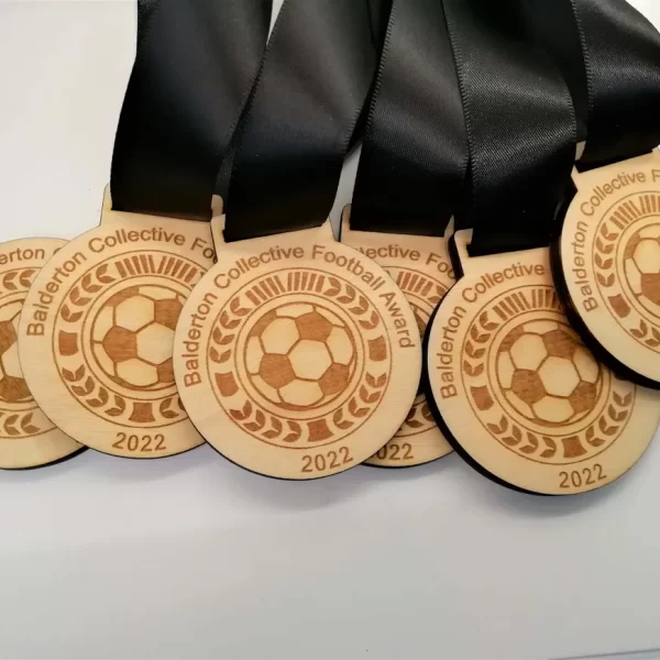 Five wooden football medals with black ribbons.
