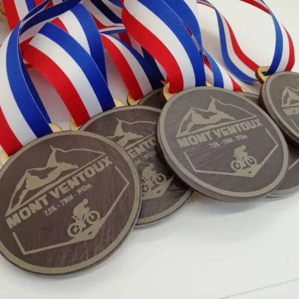 A collection of cycling medals with red, white and blue ribbons.