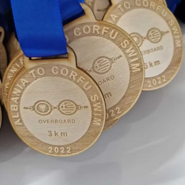 A group of wooden swimming medals with blue ribbons.