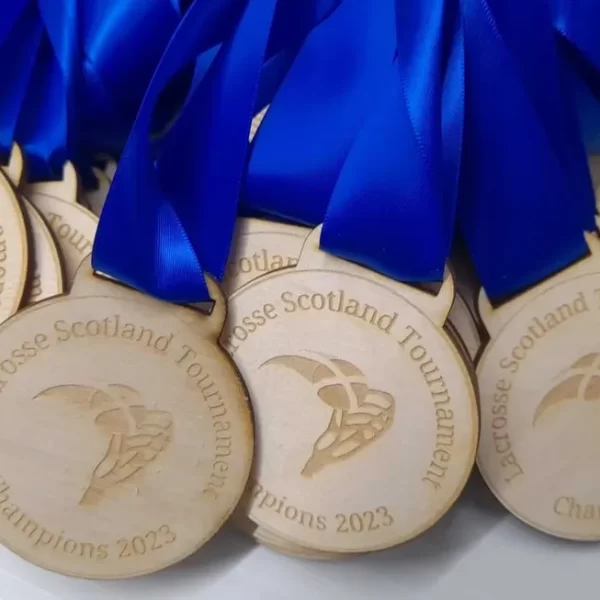 A group of wooden medals with blue ribbons awarded for swimming.