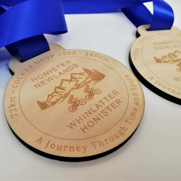 Two wooden cycling medals with ribbons on them.