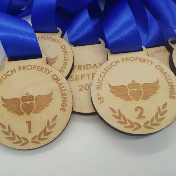 A group of wooden medals with blue ribbons on them.