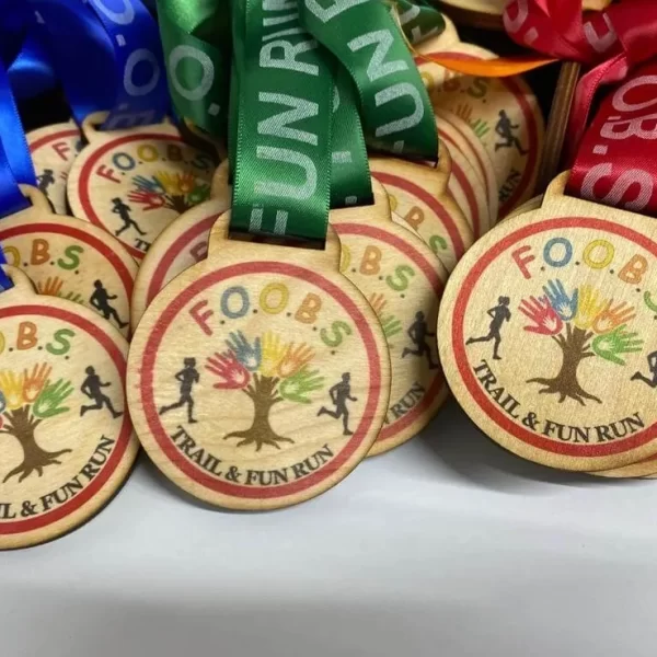 A collection of running medals made from wooden materials, complete with vibrant ribbons attached.