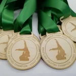 A group of wooden medals with green ribbons.