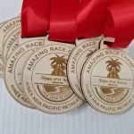 A set of wooden medals with red ribbons.
