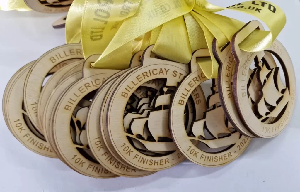 A group of wooden running medals with a yellow ribbon.