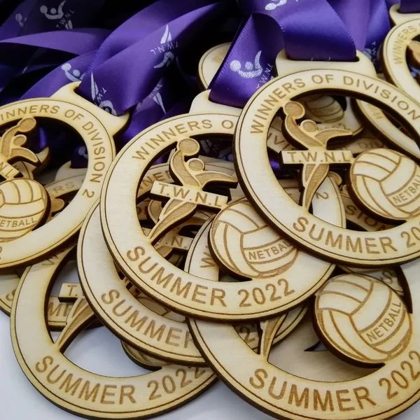Personalised volleyball medals on a purple ribbon.