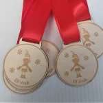 Four wooden medals with red ribbons on them.
