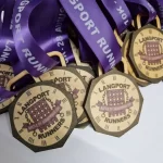 A group of race medals with purple ribbons.