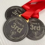 Three black and red medals with a red ribbon.