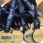 A set of eco-friendly wooden medals adorned with blue ribbons.