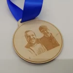 A wooden medal with a photo of two men on it.