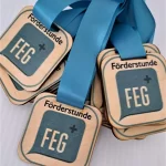 A group of wooden medals with the word feg on them.