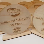 A set of wooden plaques with the words hawkhurst 10k and hawkhurst 3rd place.