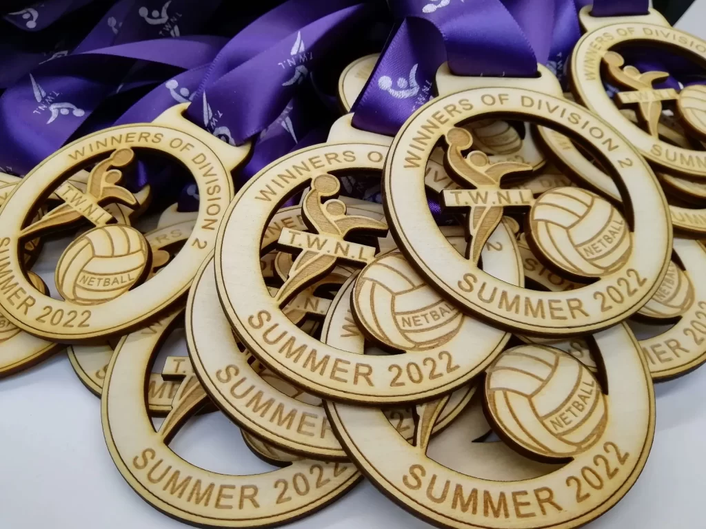 A group of swimming medals with a purple ribbon.