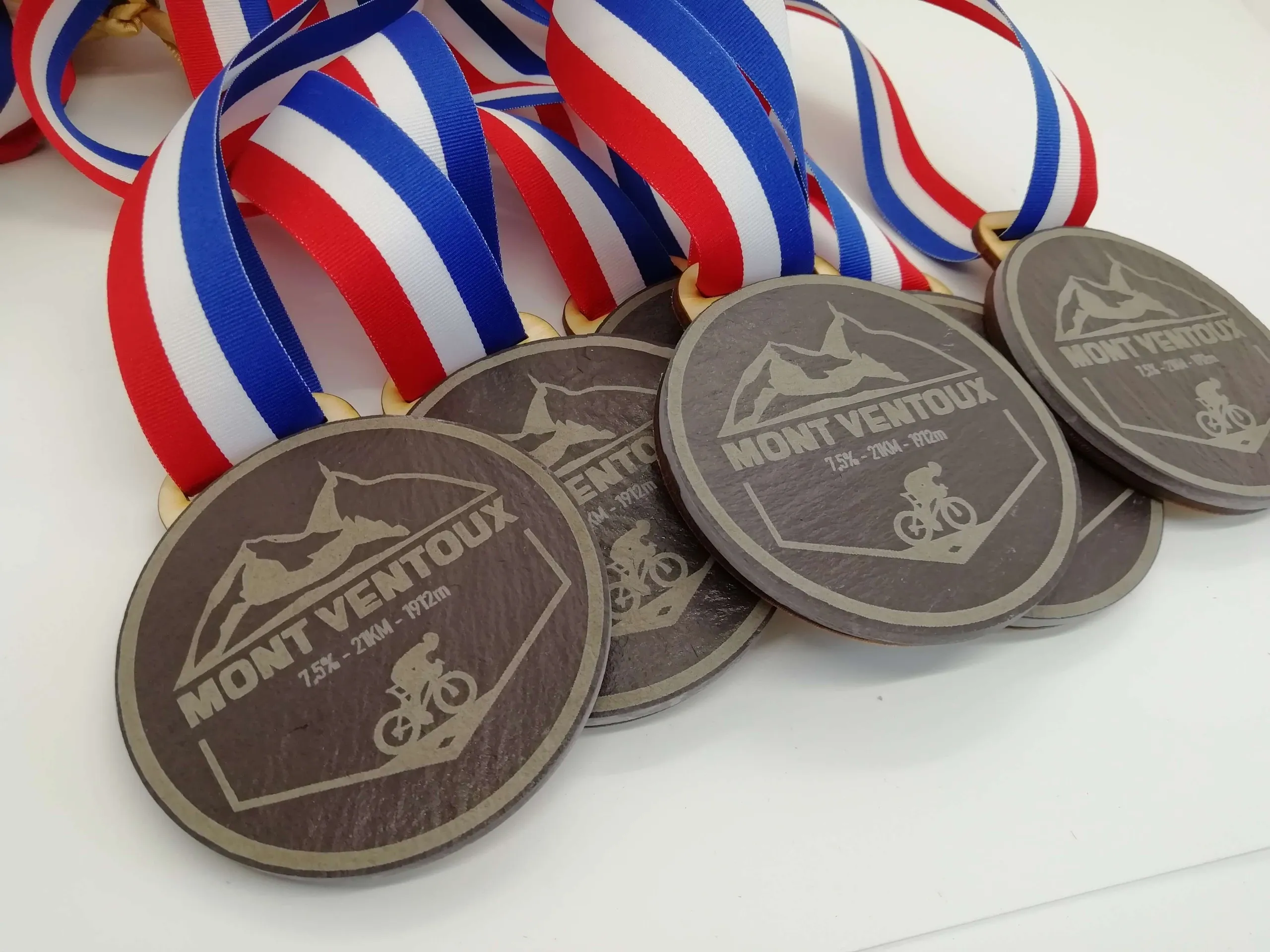 A group of eco-friendly medals with red, white and blue ribbons.