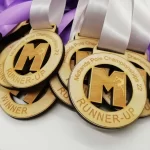 A group of wooden medals with purple ribbons.