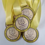 A group of medals with a yellow ribbon.