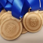 A stunning collection of wooden medals adorned with elegant blue ribbons, crafted specifically for sports enthusiasts.