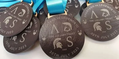A group of Eco Medals with blue ribbons on them.