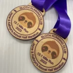 Two sloth medals with purple ribbons.