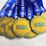 A group of school games medals with blue ribbons.