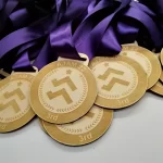 A group of medals with purple ribbons.
