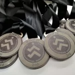 A group of medals with a black ribbon.