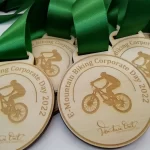 A group of wooden medals with a green ribbon.