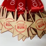 A group of wooden star medals with red ribbons.
