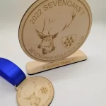 A wooden medal with a deer on it.